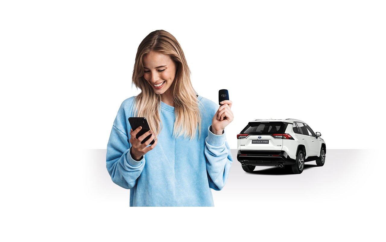 Frau mit Autoschlüssel und Smarphone in der Hand, im Hintergrund ein RAV4 Plug-in hybrid