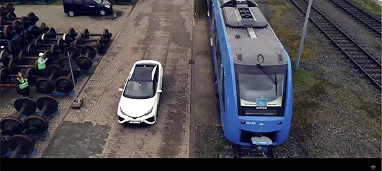 Weißer Toyota Mirai neben einer Blauen Bahn