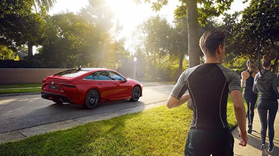 Toyota Mirai neben Joggern