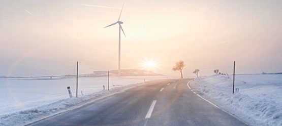 Winterlandschaft und Straße, Windrad im Hintergrund