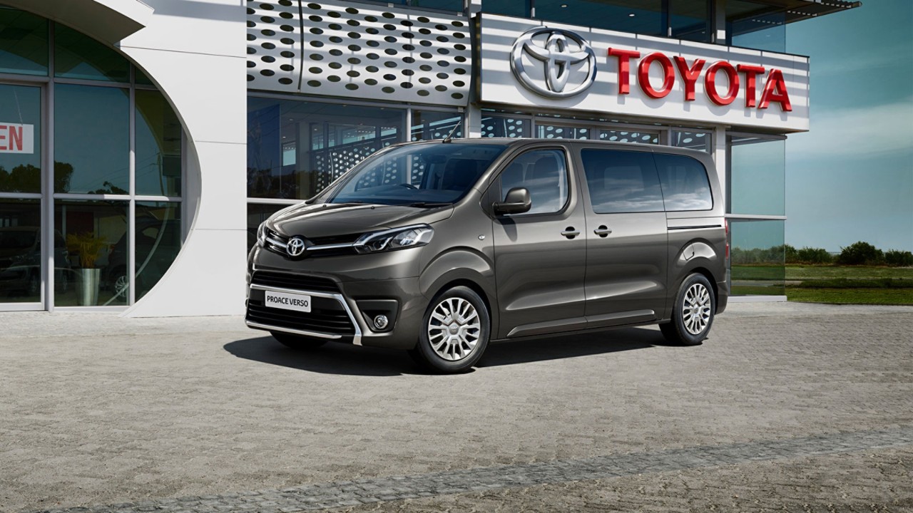Ein grauer Proace Verso steht geparkt vor einem Toyota Autohaus