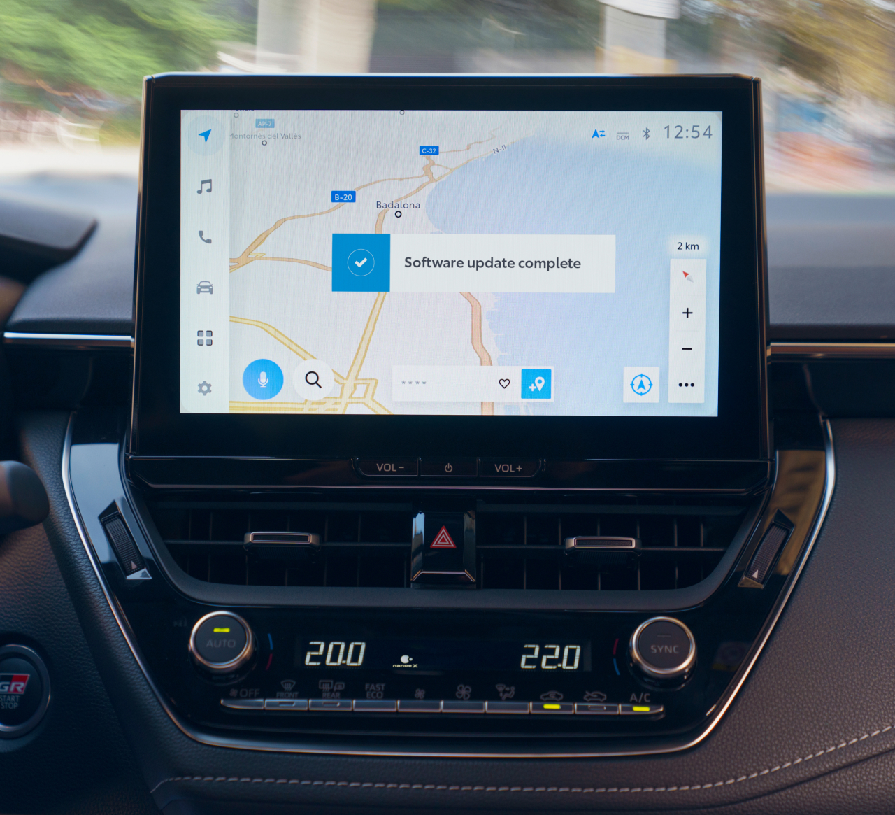 Nahaufnahme eines Multimediageräts auf dessen Bildschirm die Navigation angezeigt wird mit einer Bestätigung, dass ein Update gemacht wurde.