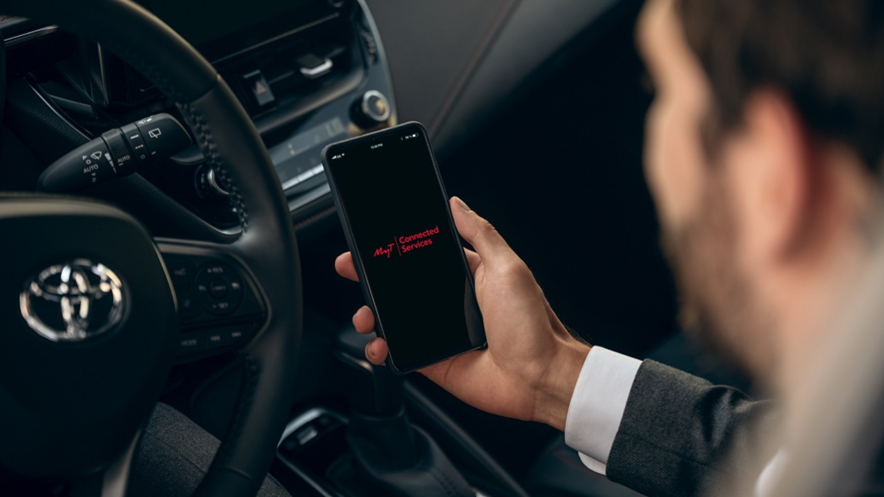Ein Mann schaut auf die MyT App auf seinem Smartphone